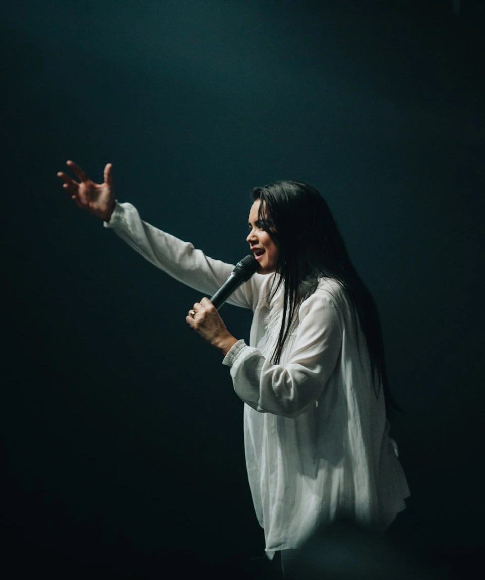 woman in long-sleeved shirt holding microphone